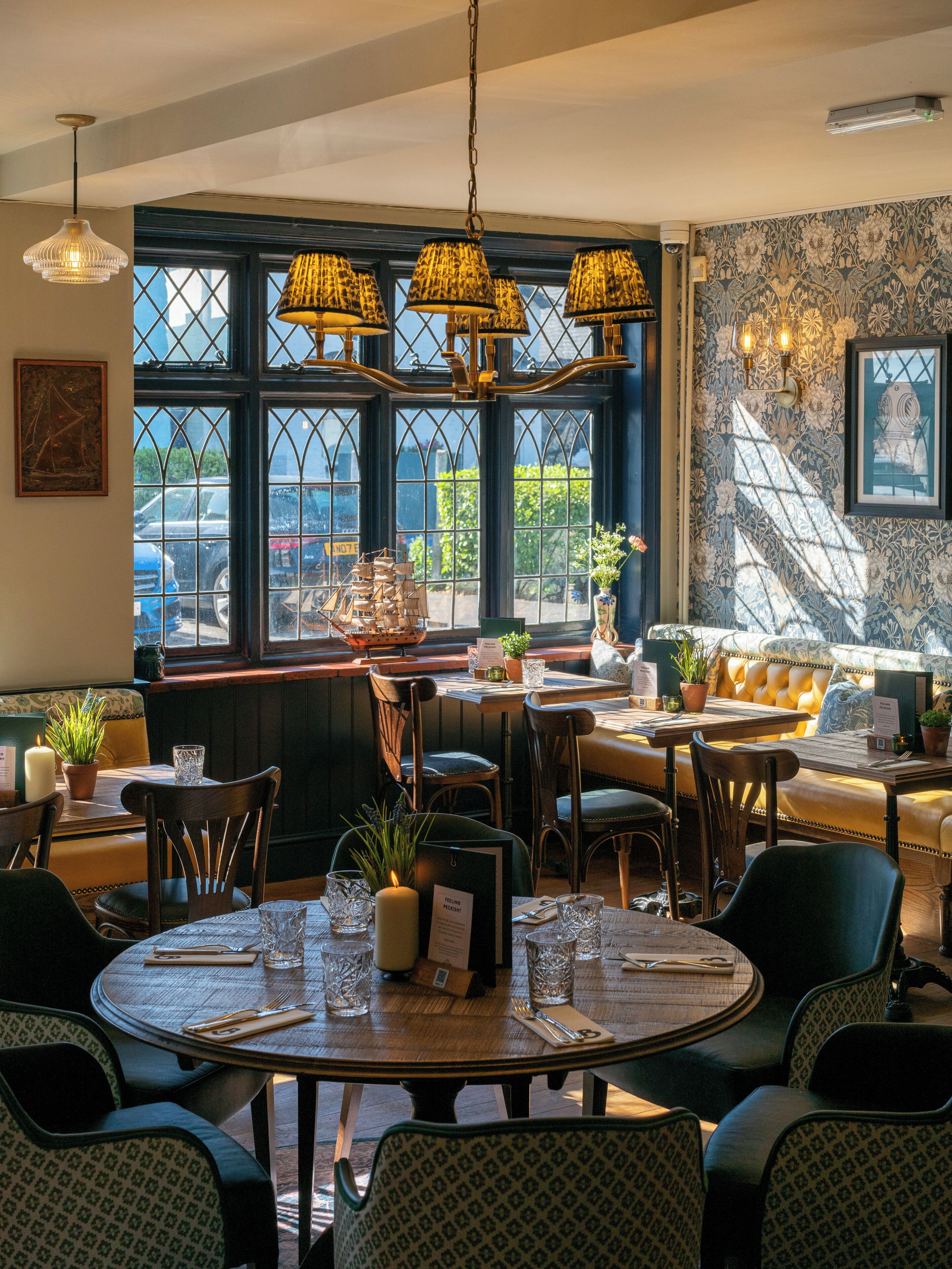 Un ristorante con tavoli rotondi, sedie e una grande vetrata con vista.