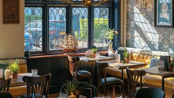 Un ristorante con tavoli rotondi, sedie e una grande vetrata con vista.