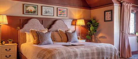 Een slaapkamer met een groot bed, nachtkastjes en een raam met gordijnen.