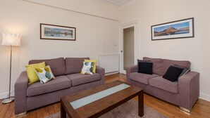A living room with two sofas, a coffee table, and two framed pictures on the walls. - Edinburgh Rossie Apartment (Edinburgh)