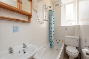 A bathroom with a bathtub, a sink, a toilet, and a showerhead. - Edinburgh Rossie Apartment (Edinburgh)