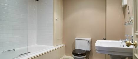 A bathroom with a bathtub, toilet, and sink.