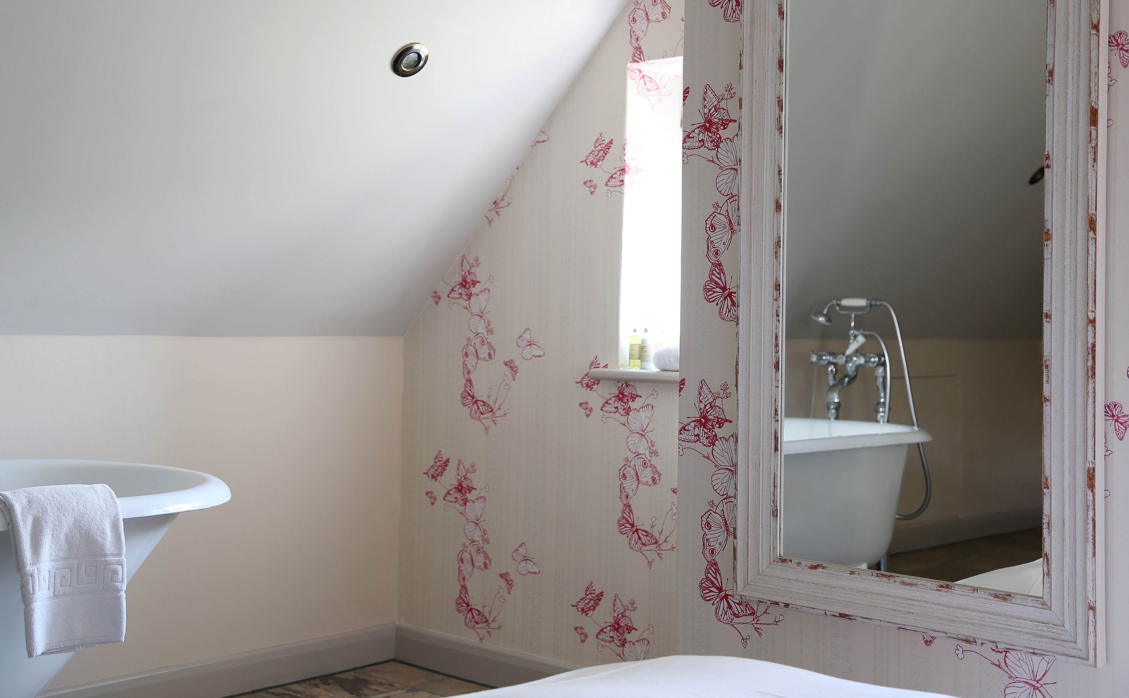 Une salle de bain avec un lavabo blanc, un miroir et une douche.