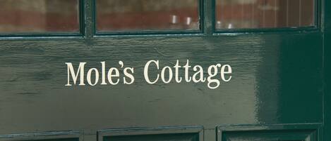 A door with the text "Mole's Cottage" indicating the name of the establishment.