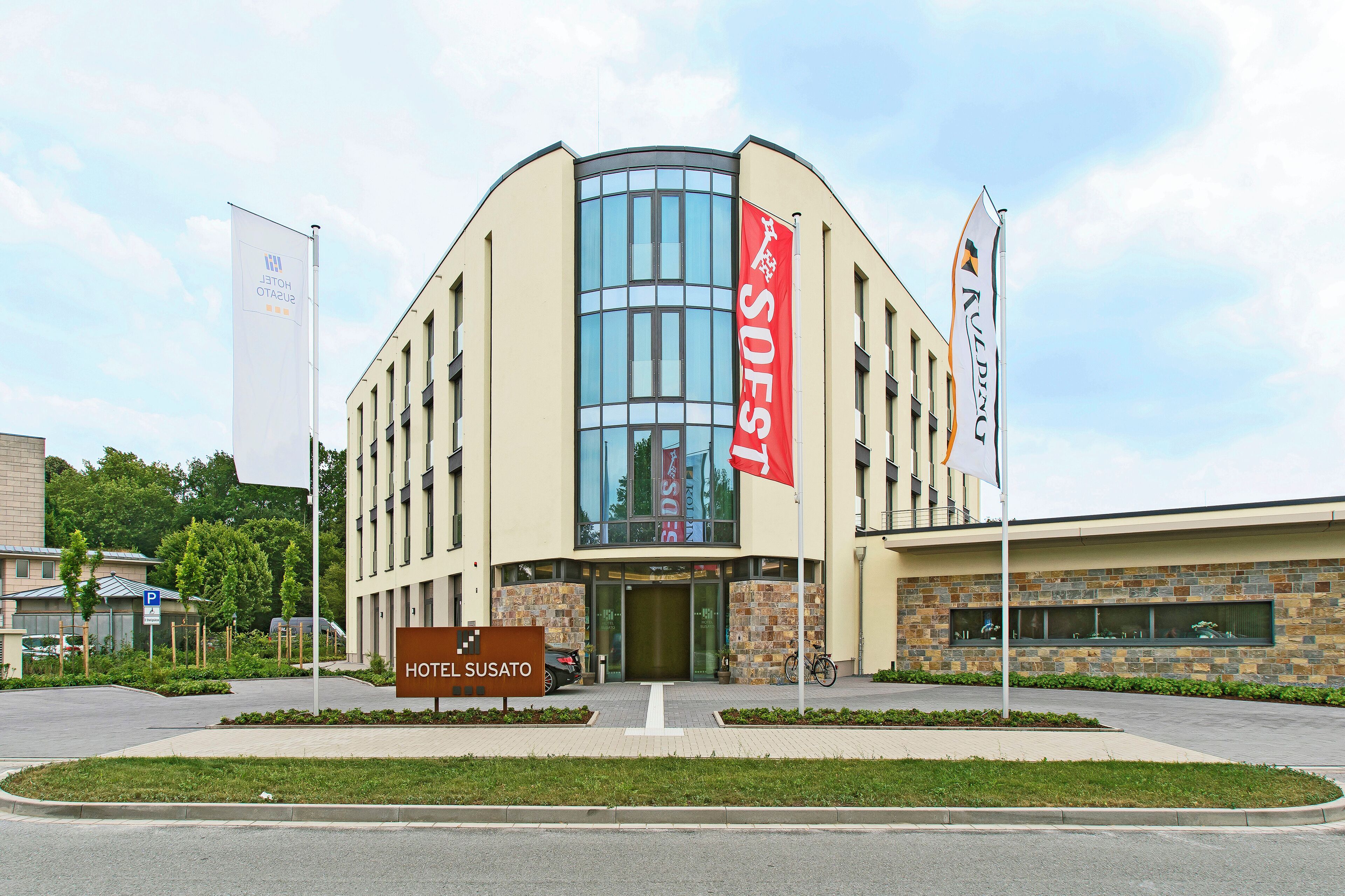 Ein Hotel mit modernem Design, gekennzeichnet durch eine auffällige Glasfassade und ein großes Schild mit dem Hotelnamen.