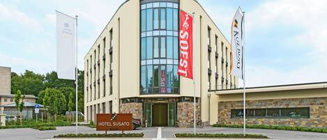 Ein Hotel mit modernem Design, gekennzeichnet durch eine auffällige Glasfassade und ein großes Schild mit dem Hotelnamen.