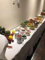 Uma mesa de buffet com diversos alimentos e acompanhamentos.