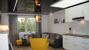 A modern living room with a yellow armchair, grey sofa, and a window with curtains. - Apartamenty Usteckie - Na Wydmie (Ustka)