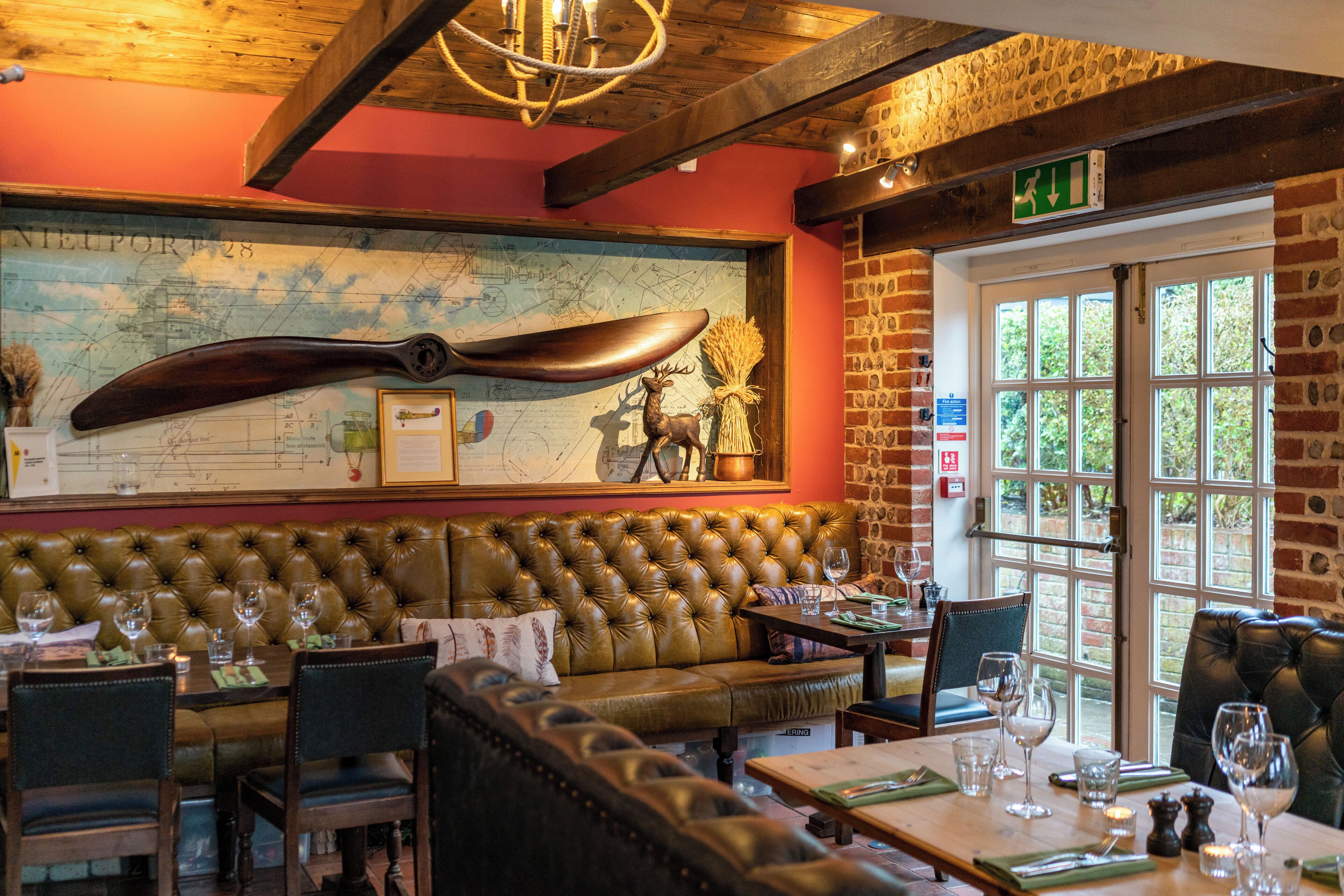 Un restaurant décoré avec une grande cuillère en bois, une carte accrochée au mur et un mur en briques.