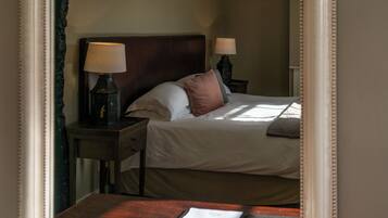 A hotel room with a large bed, two bedside tables with lamps, and a wooden headboard.