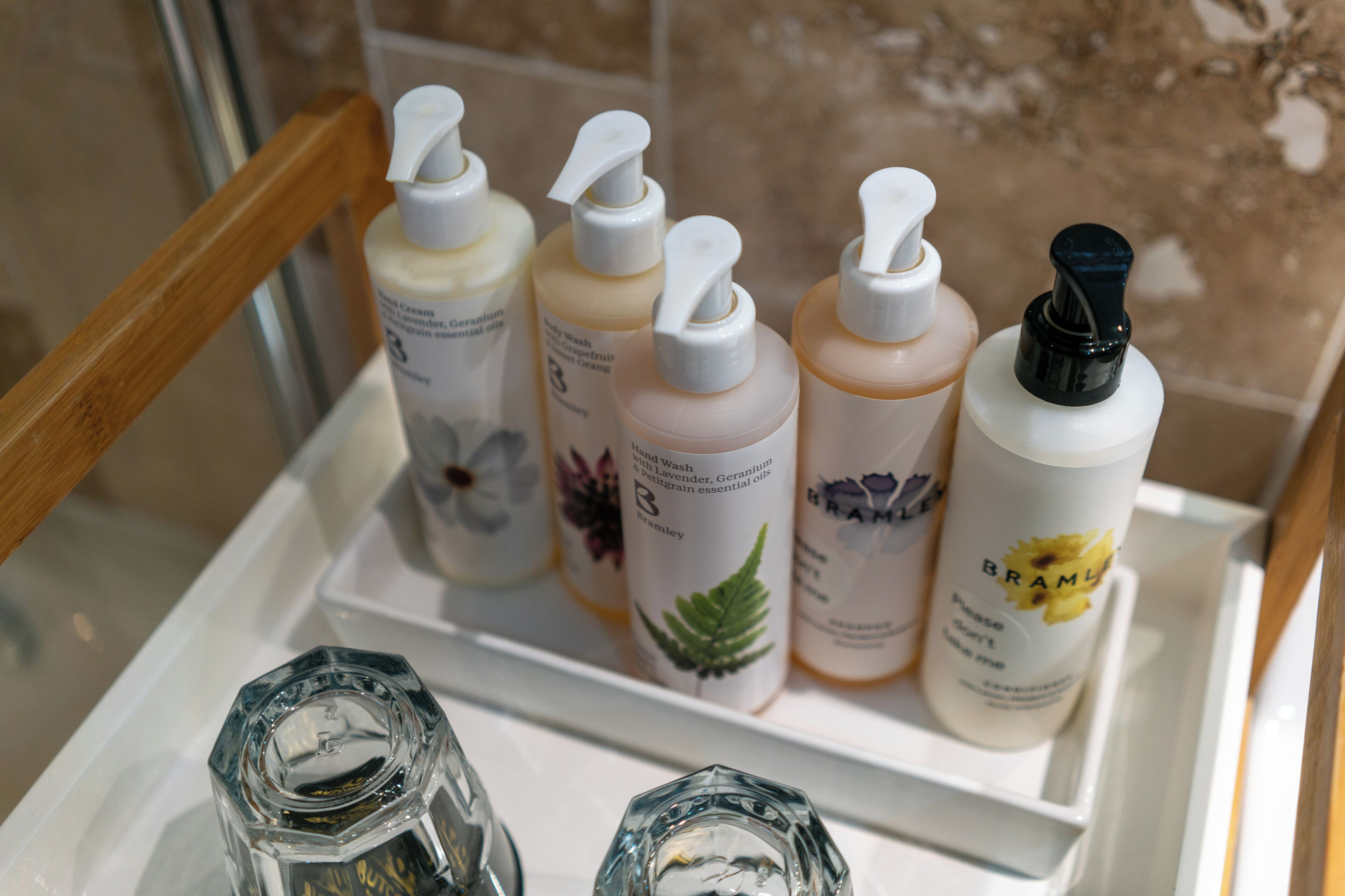 A bathroom shelf with various toiletries including hand wash, body wash, and shampoo bottles.