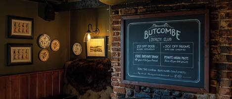A Butcombe Loyalty Club signboard with details on offers and amenities.