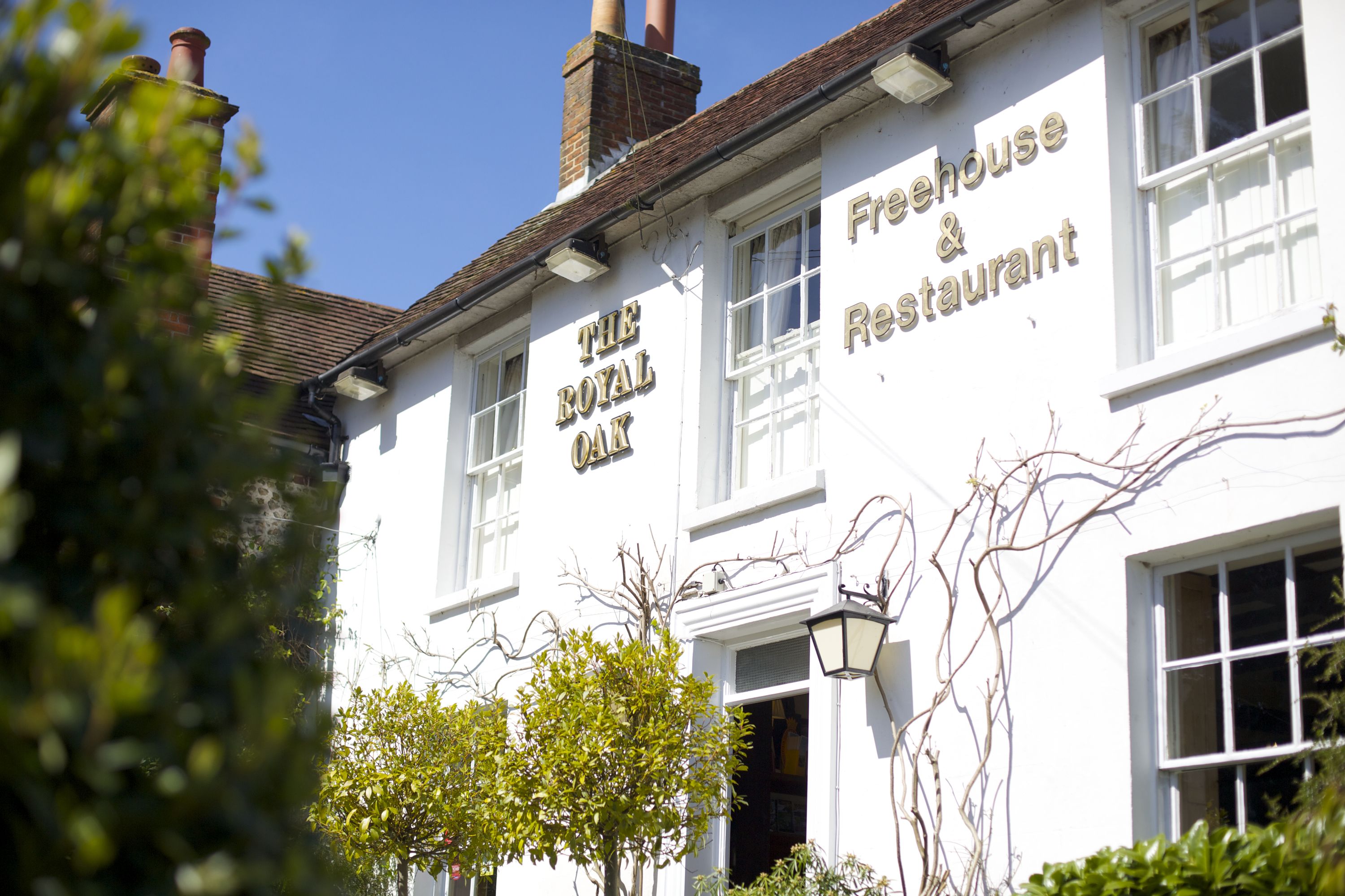 A white building with the sign "The Royal Oak Freehouse & Restaurant" on its facade.