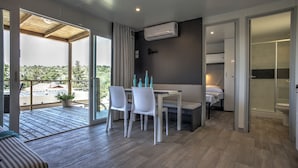 A modern room with a dining area, a bed, and a bathroom. - Camp Rehut - Campsite (Murter-Kornati)