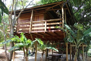 A wooden structure with a wooden deck, surrounded by trees and plants. - Shambala Piri (Pirenópolis)