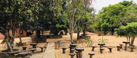 Un jardín con bancos de piedra y árboles.