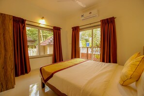 A hotel room with a bed, curtains, a window, and an air conditioning unit. - OYO 9792 Home 2BHK Poolside Siolim (Oxel)