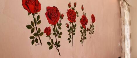 A wall with a series of red roses painted on it.