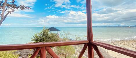 A wooden structure with a view of the sea and a distant island.