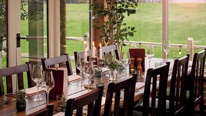 A dining table set for a meal with candles, wine glasses, and a menu. - The Welldiggers Arms (Petworth)