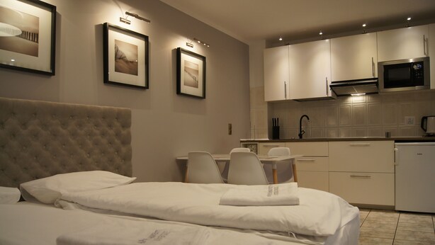 Ein Hotelzimmer mit Bett, Schreibtisch und einer Küchenzeile.