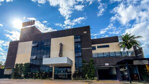 A modern hotel with a prominent sign, large windows, and a covered entrance. - Hotel Caribe (Porto Velho)