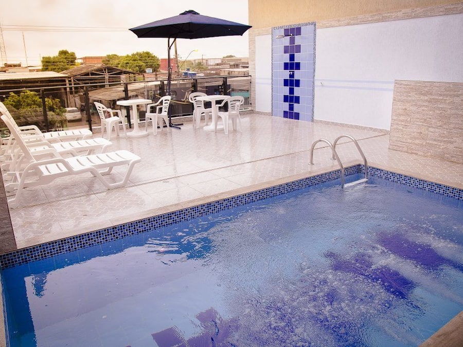 Een buitenzwembad, ligstoelen bij het zwembad