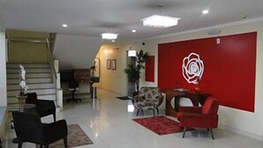 A hotel lobby with a staircase, a reception desk, and seating areas. - Hotel Caribe (Porto Velho)