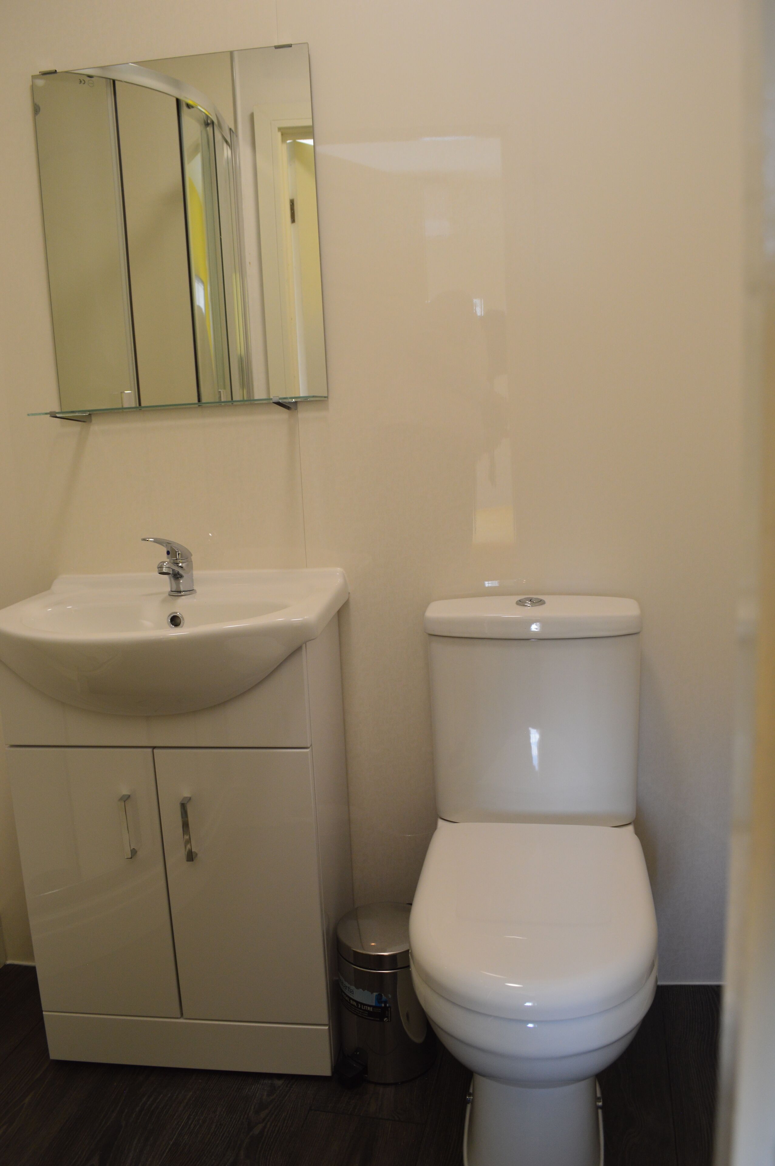 Ein Badezimmer mit Waschbecken, Toilette und Spiegel über dem Waschbecken.