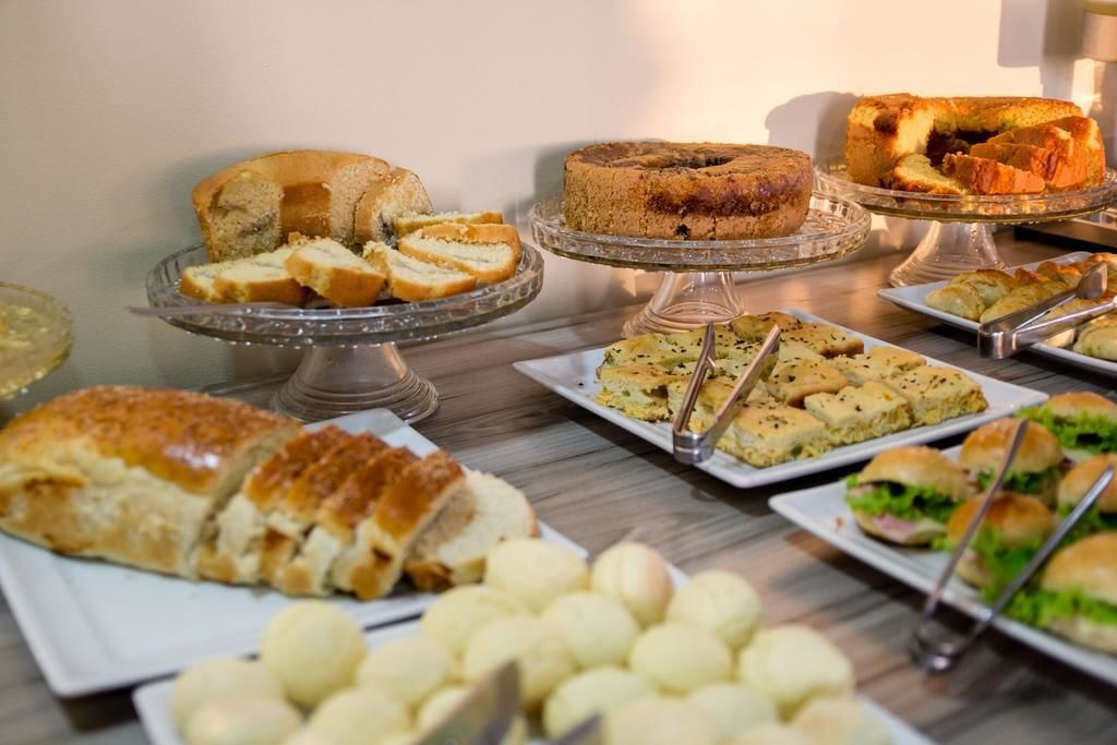 A buffet table with various food items including cakes, pastries, and sandwiches.