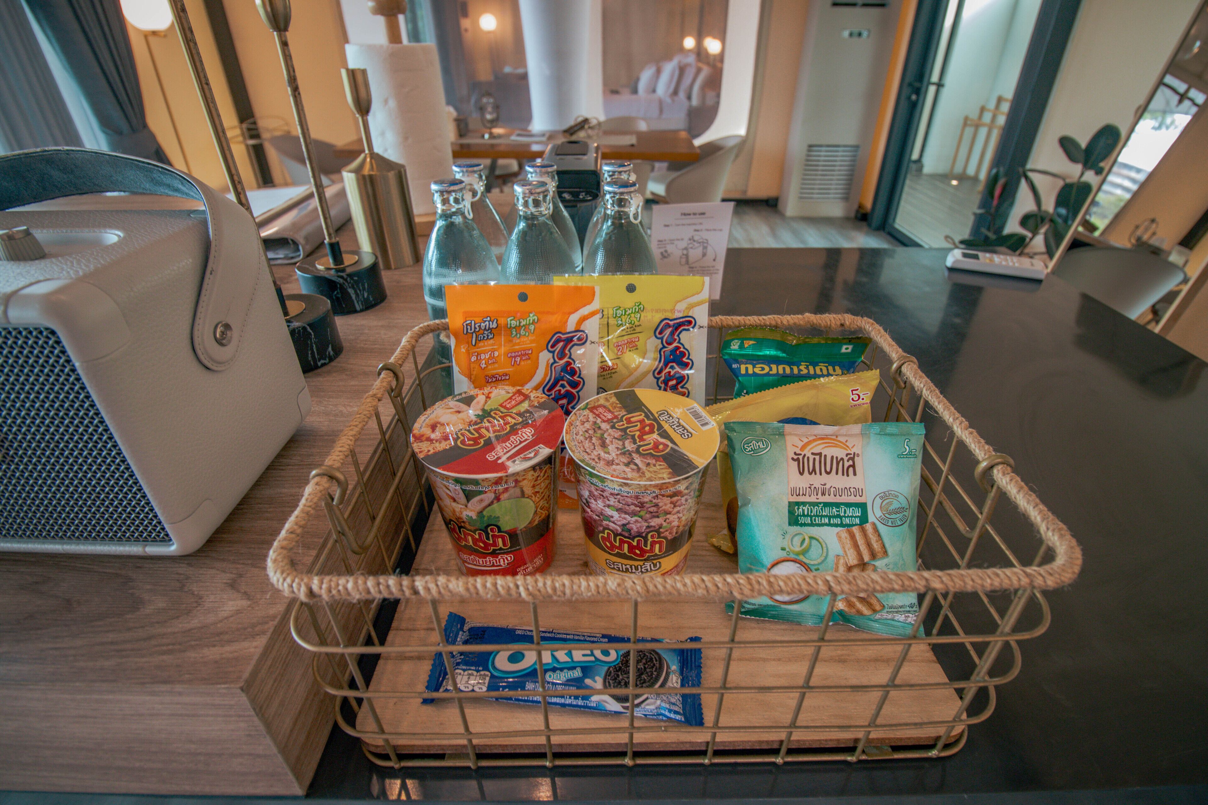 Una cesta con alimentos y una computadora portátil sobre una mesa.