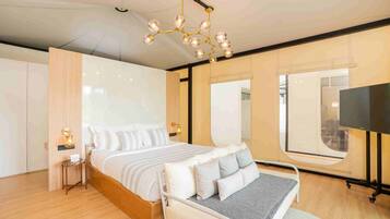 Una camera da letto moderna con un letto grande, comodini, una TV e un lampadario originale.