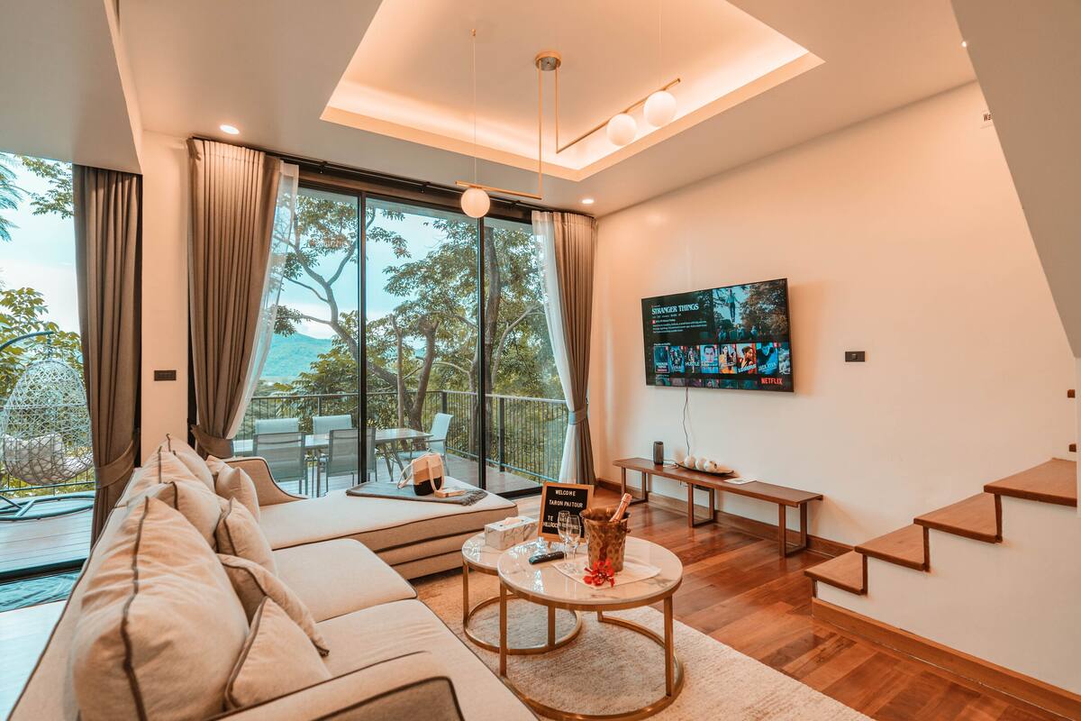 Una sala de estar moderna con sofá, mesa de centro y televisor montado en la pared.