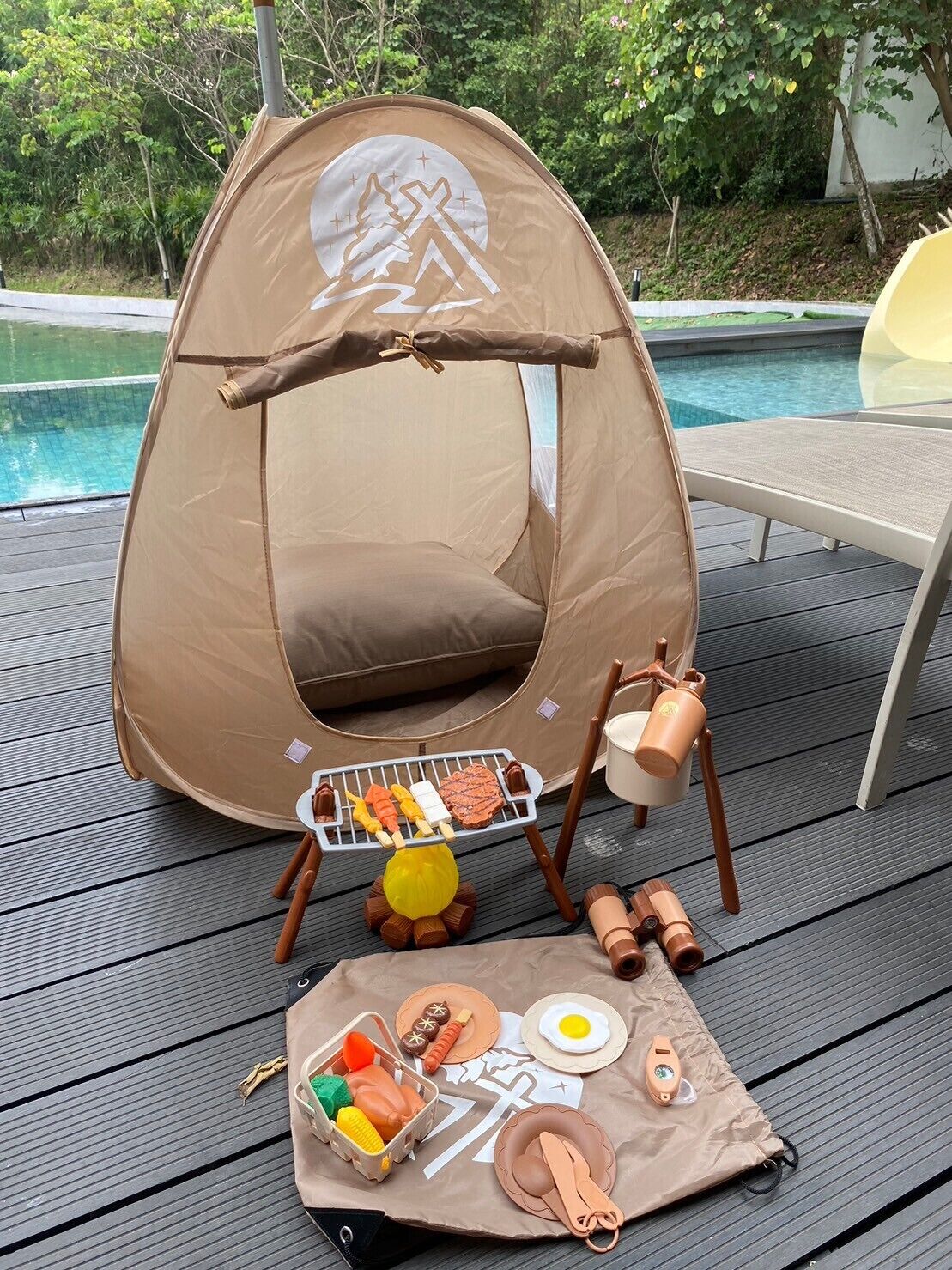 Una tenda amb un conjunt de graella per a cuinar, un fogueró portàtil i un estri per dinar amb aliments.