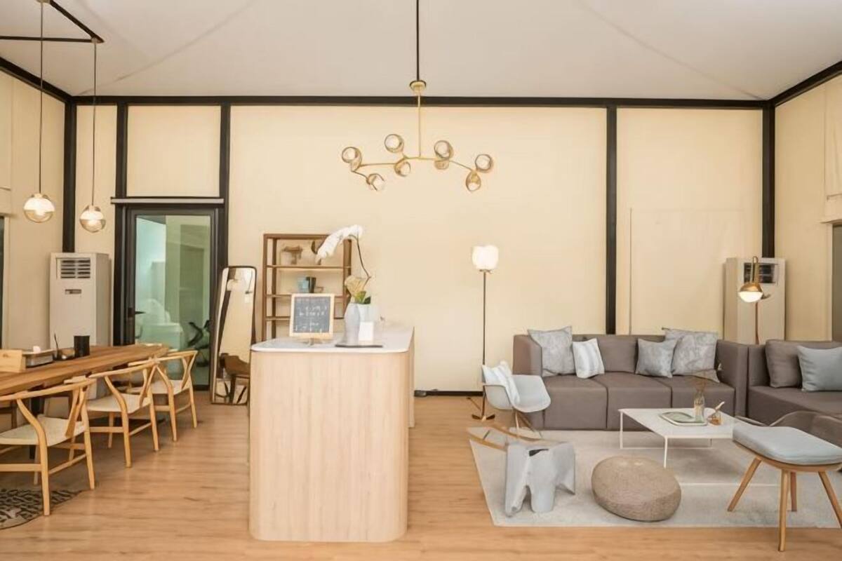 Una sala de estar moderna con una mesa de comedor de madera, un sofá, una mesa de centro y una isla central.