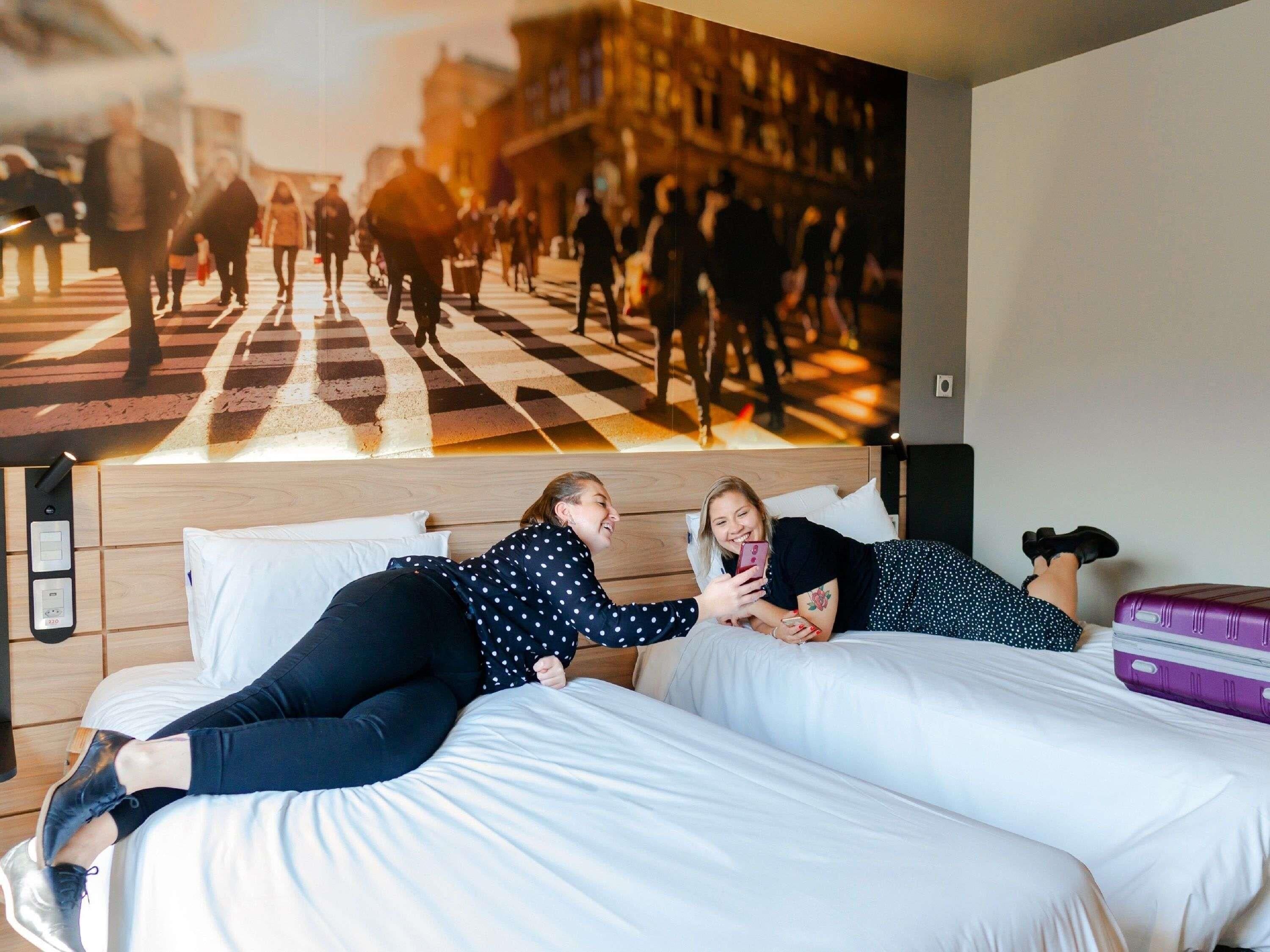 أسرّة بطبقة علوية مريحة وميني بار وخزنة داخل الغرفة ومكتب