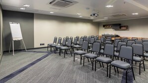 A conference room with rows of chairs, a whiteboard, and a podium. - Novotel Curitiba Batel (Curitiba)
