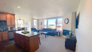 A spacious living area with a large island, a sofa, and a television. - Rockaway Shores (Rockaway Beach)