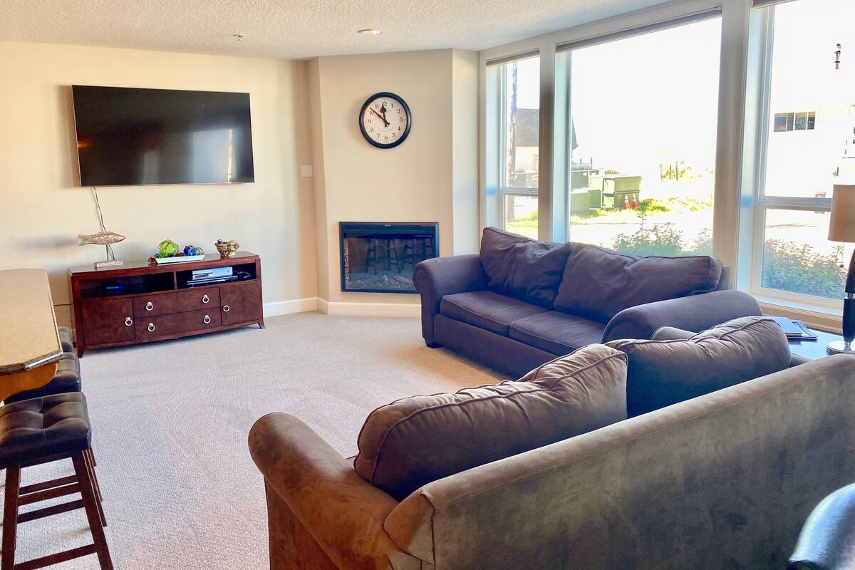 Una sala de estar con una televisión de pantalla plana grande, una chimenea y un sofá.
