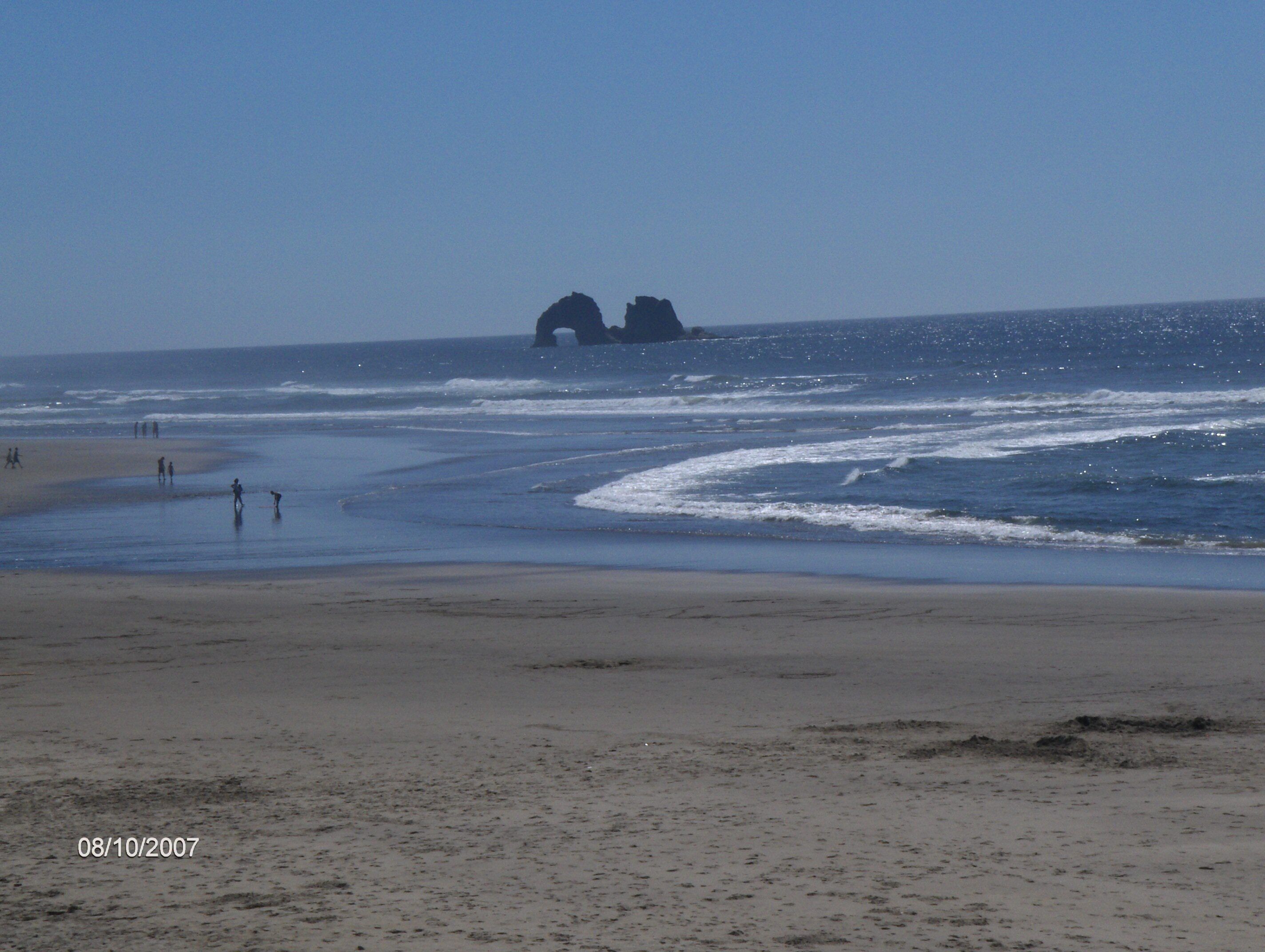A beach with a clear sky, waves, and a date stamp of 08/10/2007.