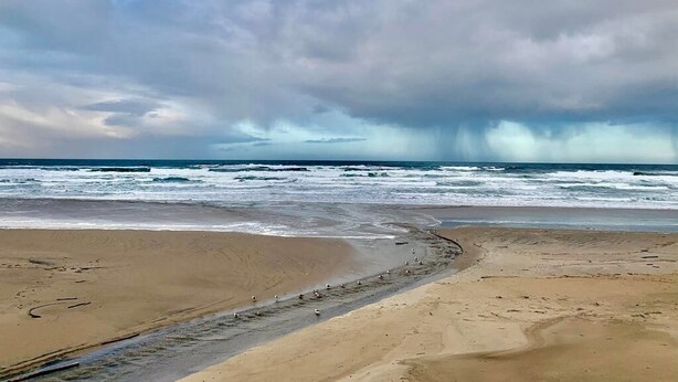 A beach with a sandy shore and waves crashing onto the beach. - Rockaway Shores (Rockaway Beach)