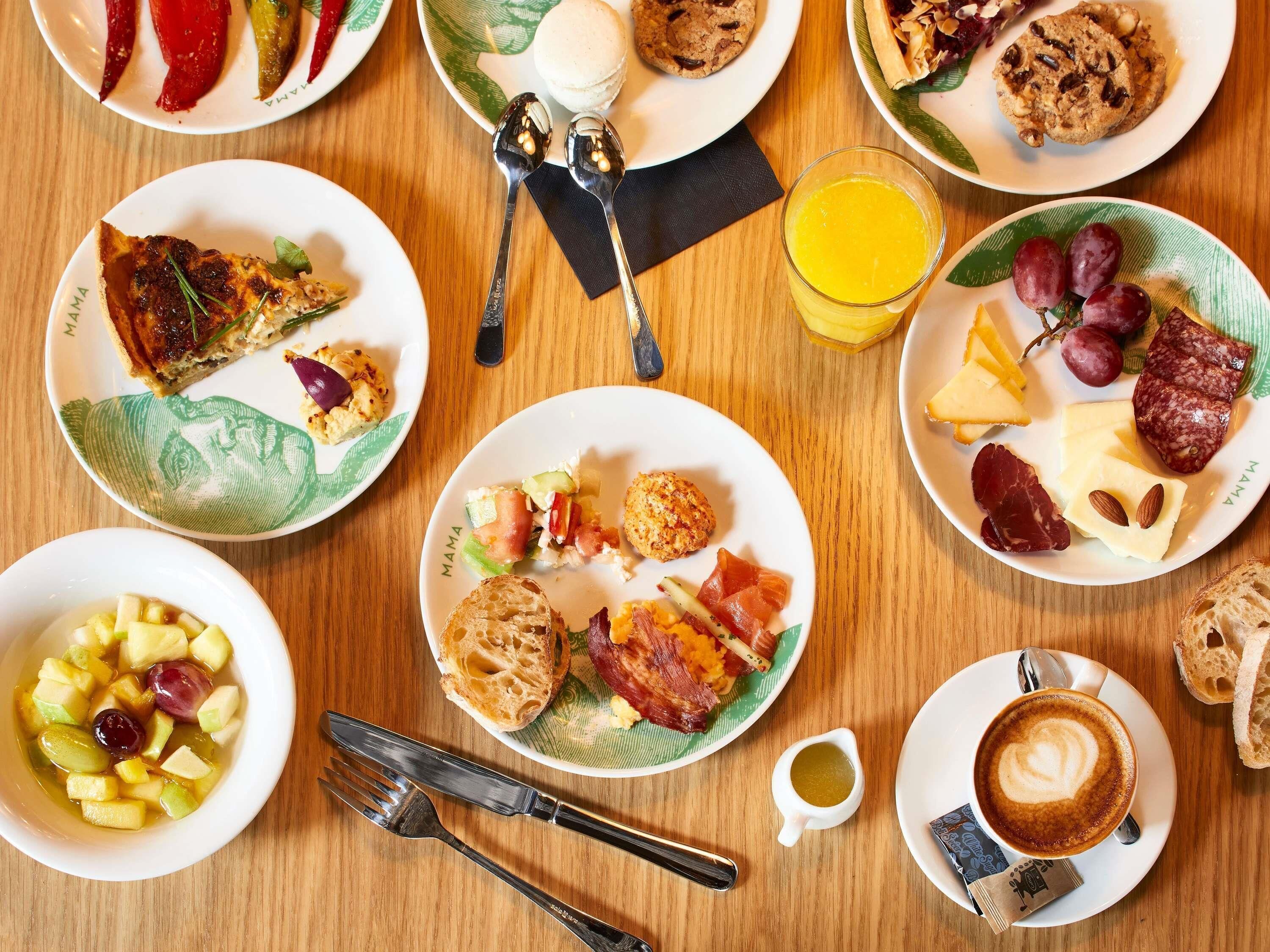 A breakfast setting with plates of food, a glass of orange juice, and a cup of coffee.