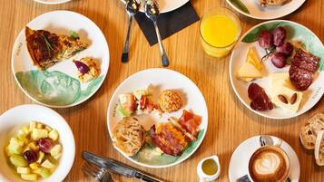 A breakfast setting with plates of food, a glass of orange juice, and a cup of coffee.
