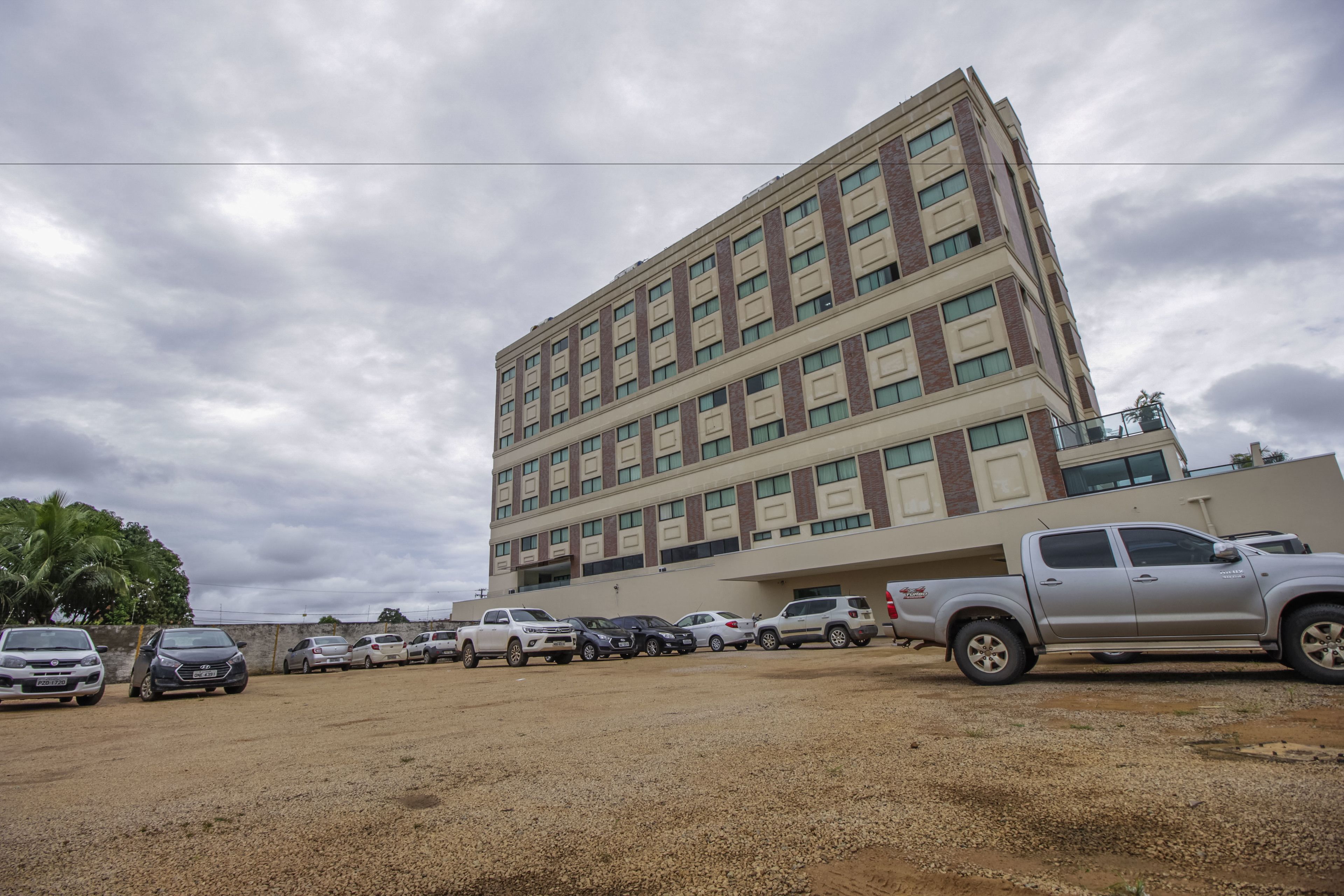 A multi-story building with a parking lot in front.