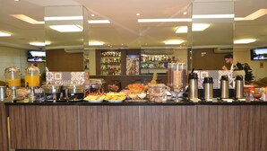 A breakfast buffet with various food items and beverages. - Golden Plaza Hotel by Easy Class (Porto Velho)