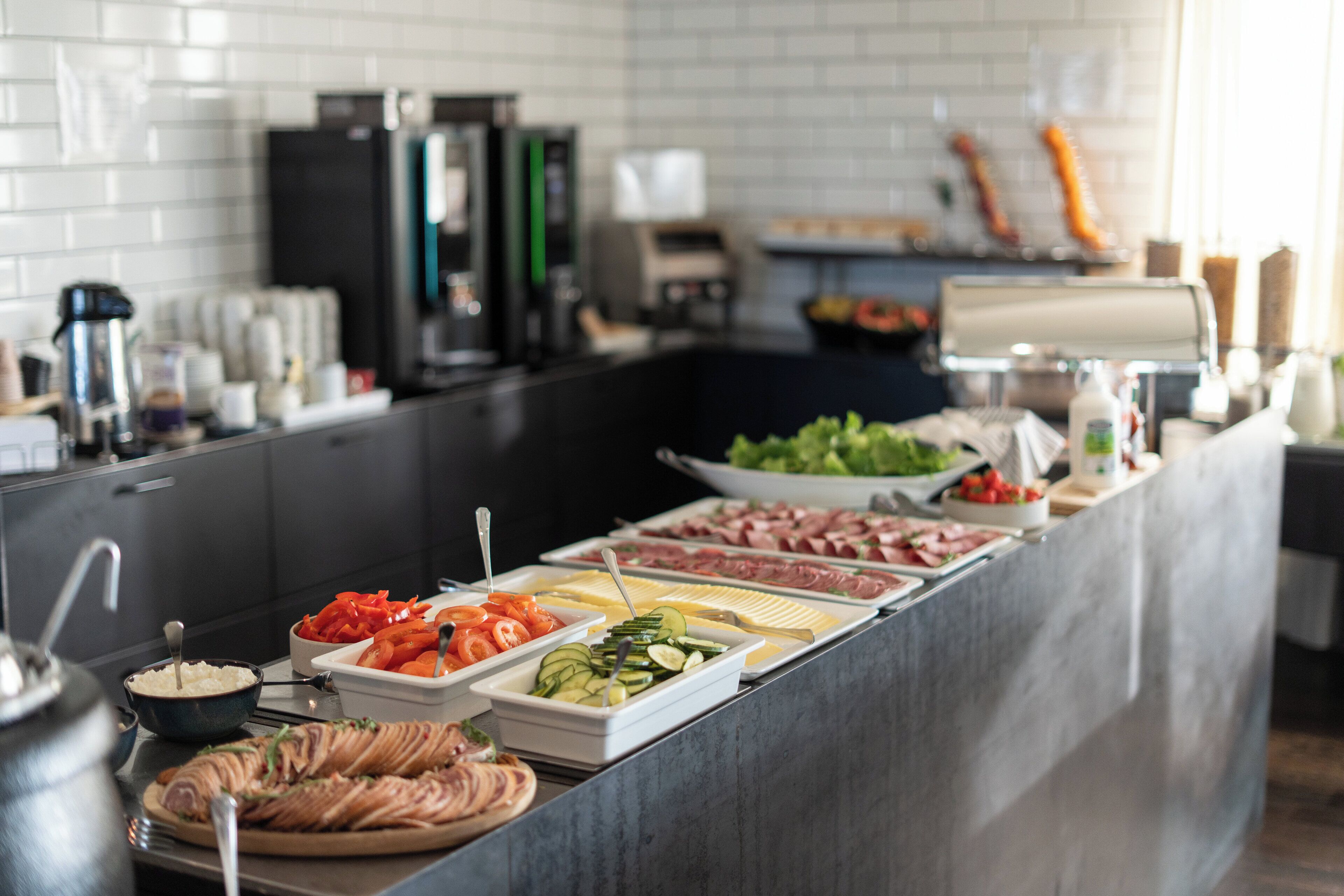 Een buffet met diverse gerechten, waaronder vlees, groenten en salades.