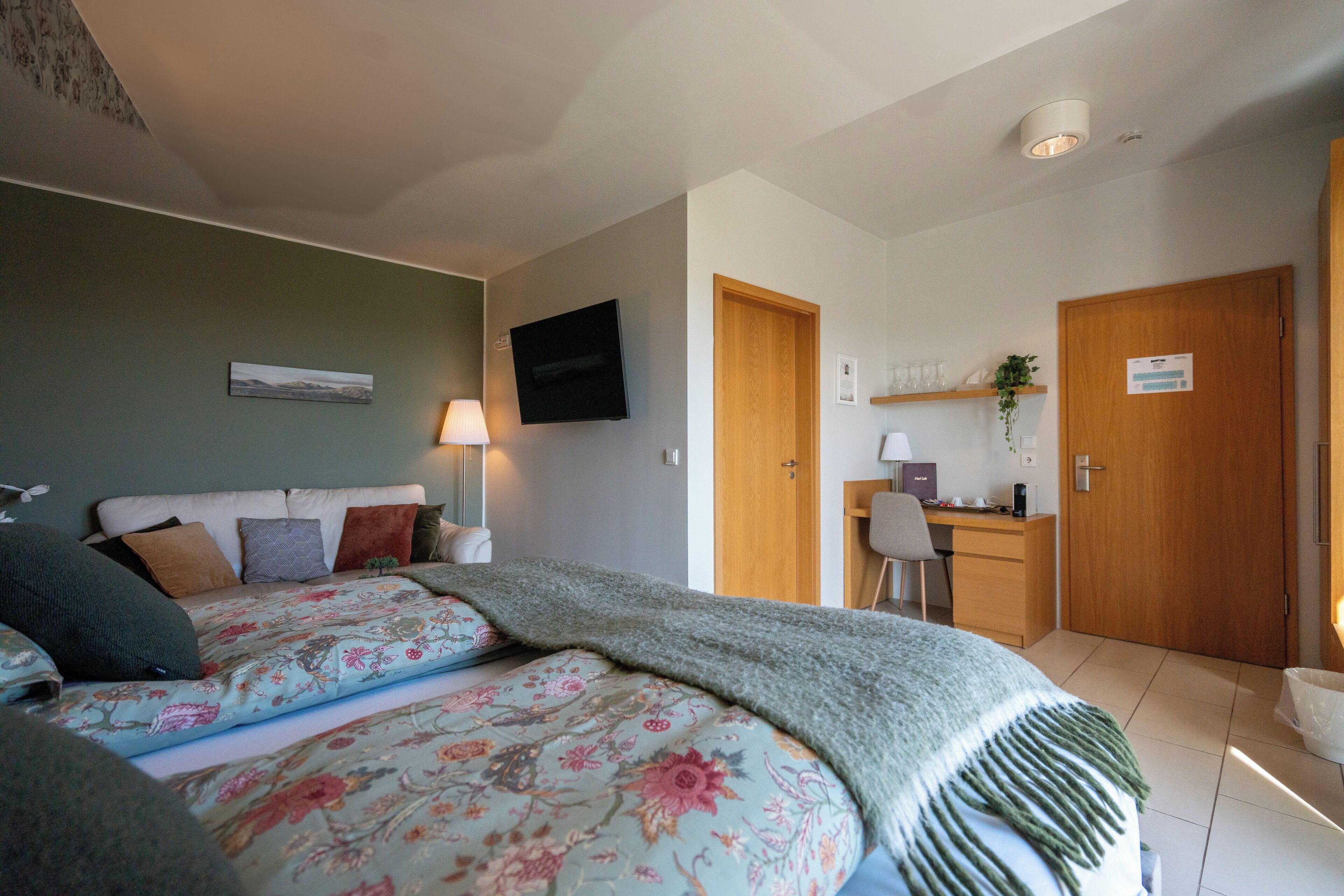 Un dormitorio con cama, escritorio y silla.