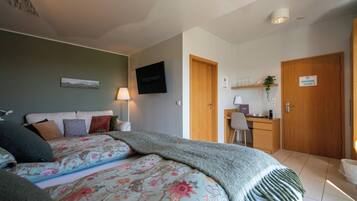 Un dormitorio con cama, escritorio y silla.