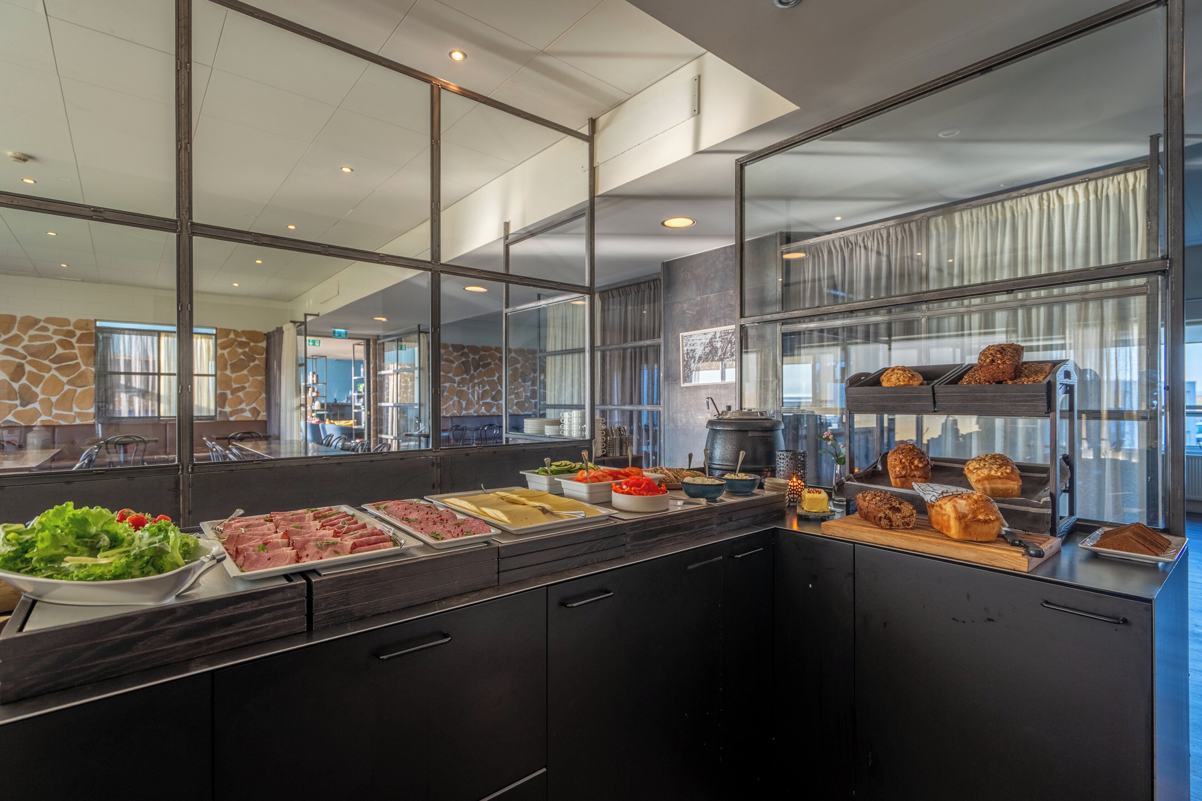 Un'area buffet con diverse opzioni gastronomiche, tra cui insalate, carni e prodotti da forno.