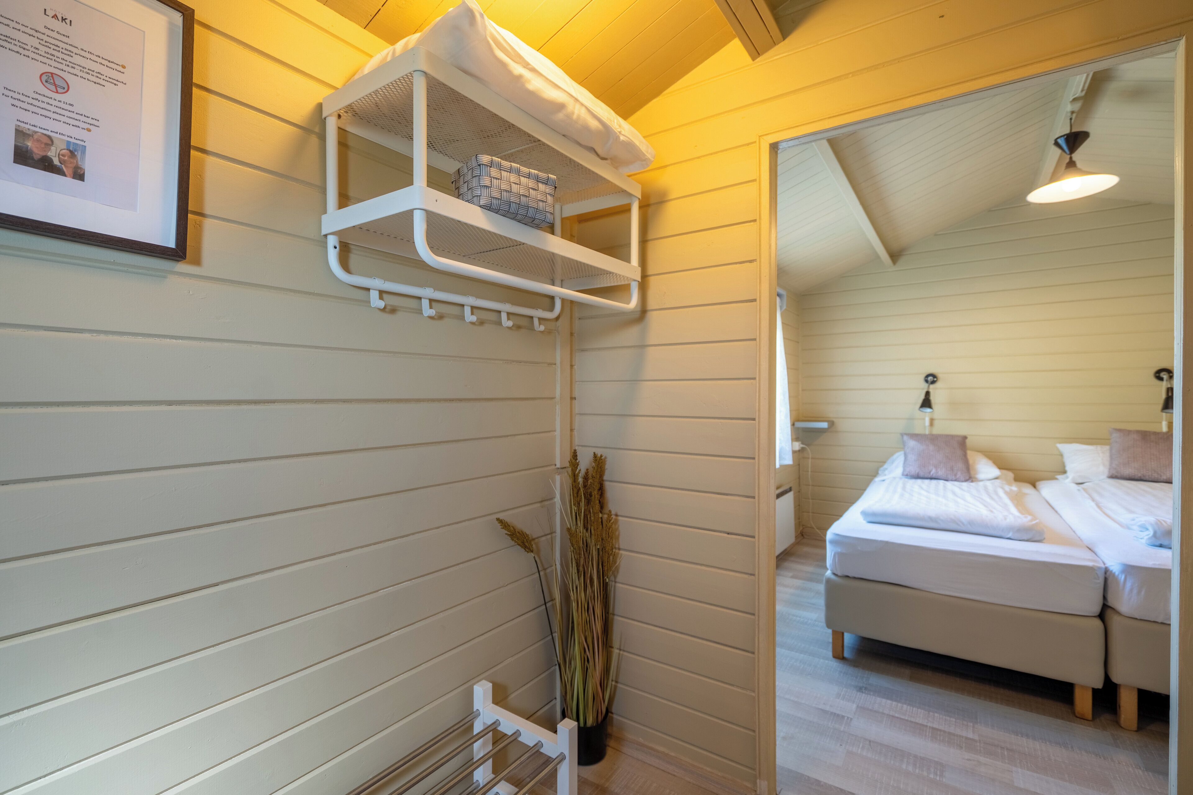 Une chambre avec un lit superposé, une table de chevet, une lampe et un certificat encadré accroché au mur.
